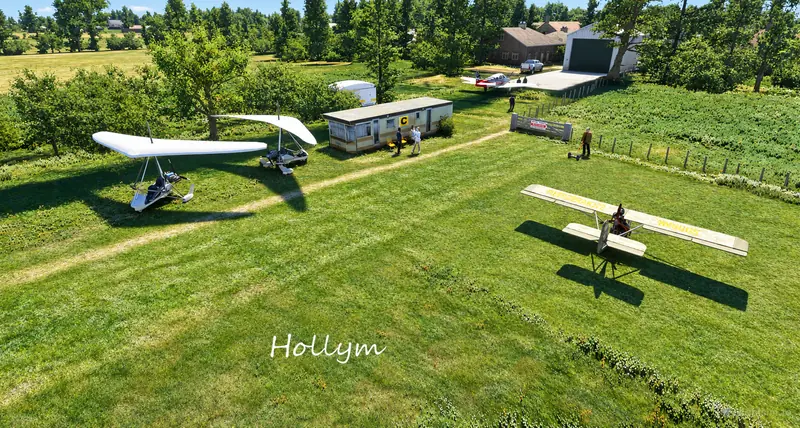 Microlights and a light aircraft parked by the clubhouse caravan at Hollym farm strip in Microsoft Flight Simulator