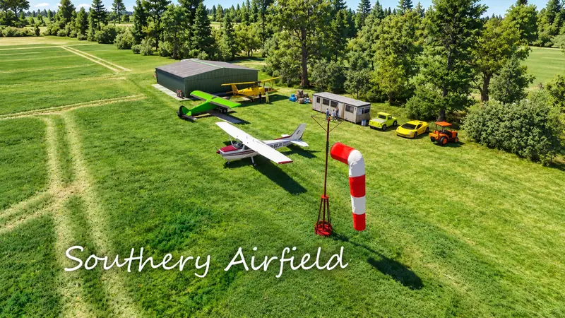 Windsock, Cessna and biplane outside the hangar at Southery Airfield in Microsoft Flight Simulator